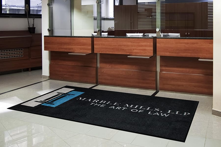 Custom logo floor mat with company branding at business entrance.