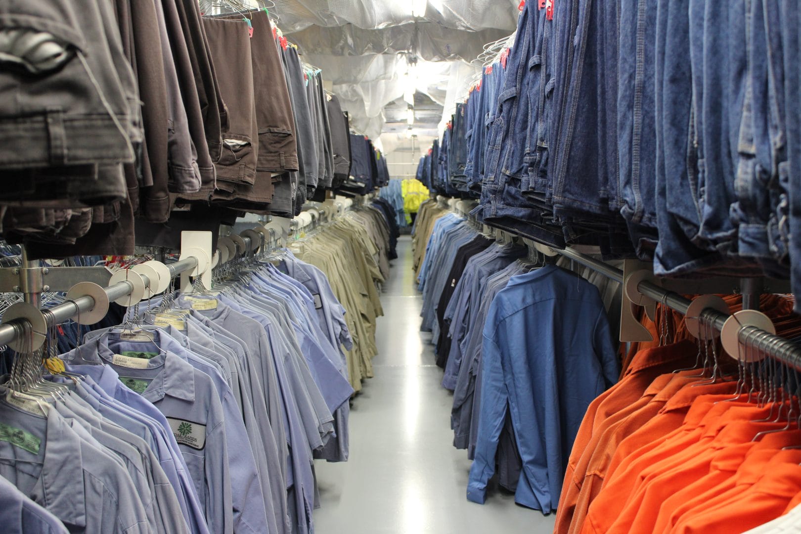 Close-up of clean, branded uniforms neatly folded and ready for distribution in a workplace.