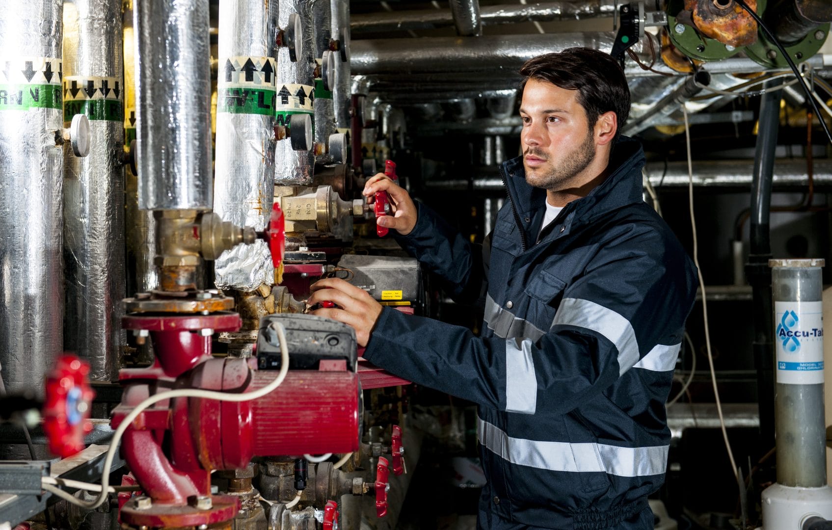Industrial Manufacturing employee working on a machine in his rented uniform.