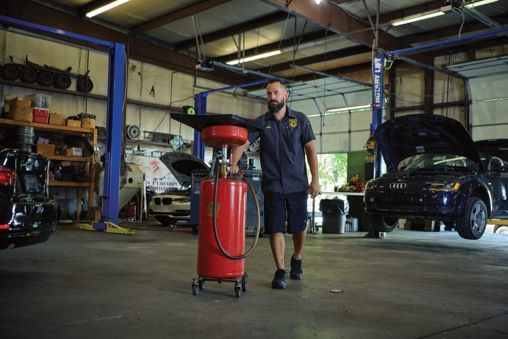 Automotive technicians in matching uniforms working in a professional auto repair shop