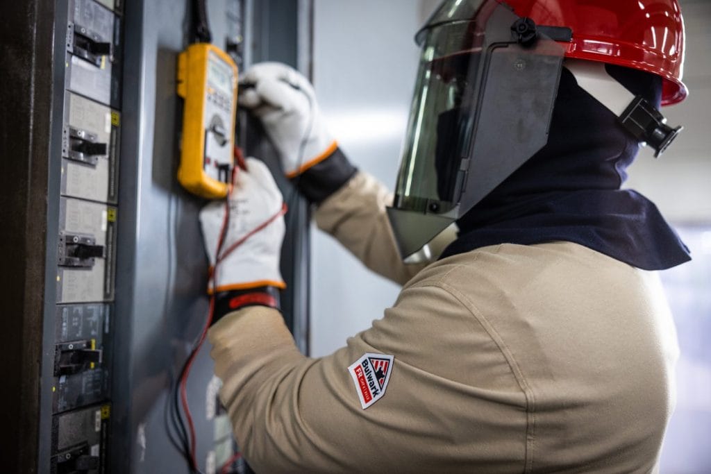 Worker wearing flame-resistant FR apparel in an industrial environment
